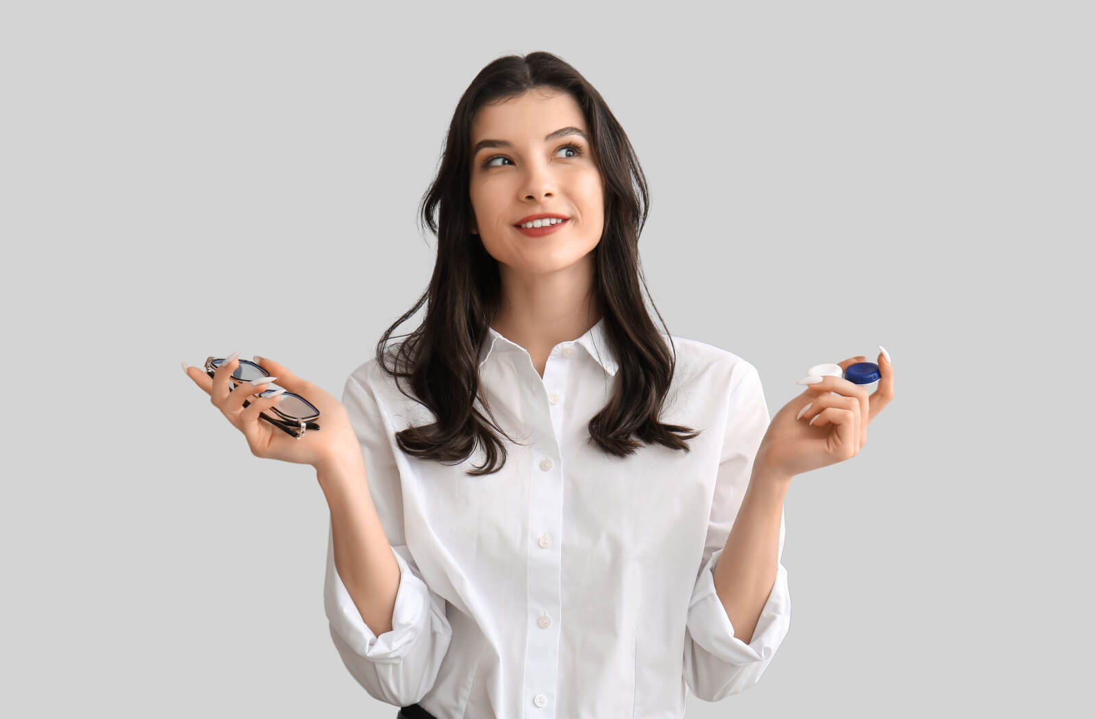 A person smiling while trying on a pair of glasses in an optical shop.